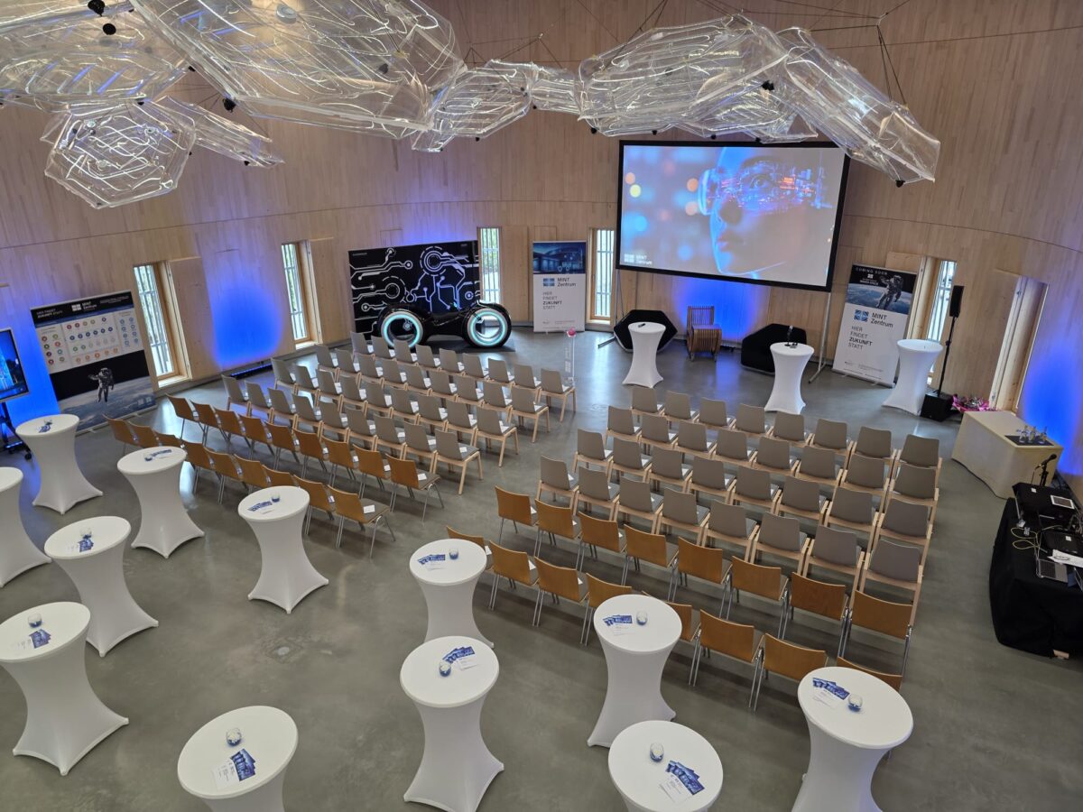 Veranstaltungsarena im Ellipsum Hirschaid mit Reihenbestuhlung und Stehtischen – Blick von der Galerie auf flexible Event- und Tagungsflächen